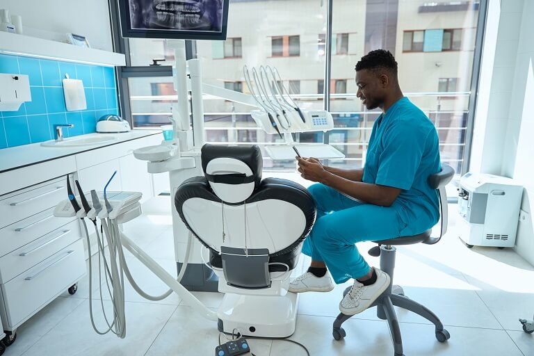 Dentista conferindo as redes sociais em consultório.