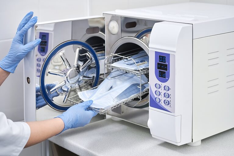 Instrumentais sendo inseridos em autoclave para esterilização.