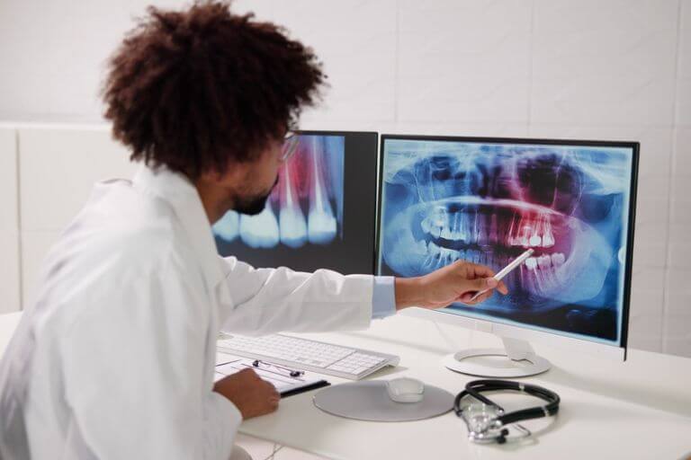 cirurgião dentista atualizando prontuário de paciente odontológico